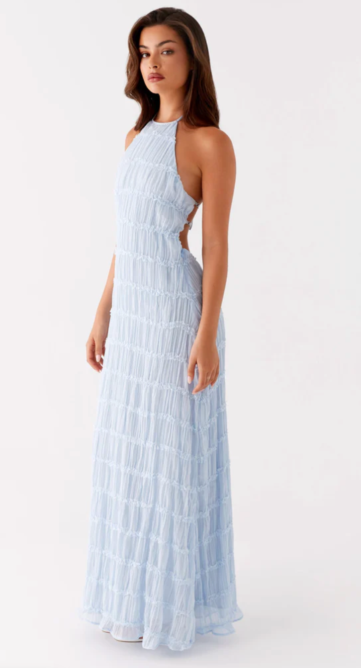 Woman wearing a light blue halter neck dress on a white background