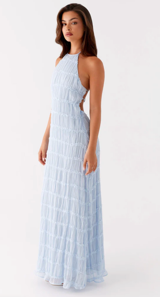 Woman wearing a light blue halter neck dress on a white background