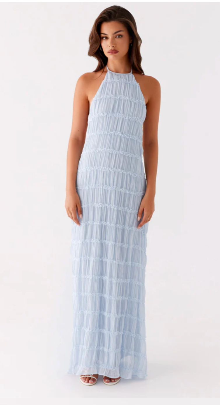 Woman wearing a light blue halter neck dress on a white background